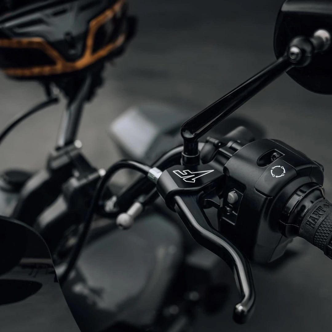 Close-up of motorcycle handlebar controls with a blurred background