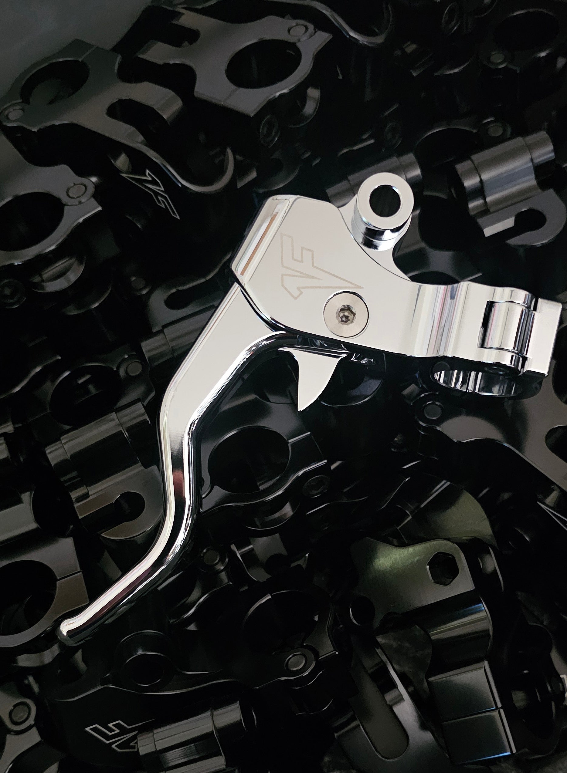 Close-up of Chrome 1FNGR easy pull clutch lever for Harley Davidson on a dark background